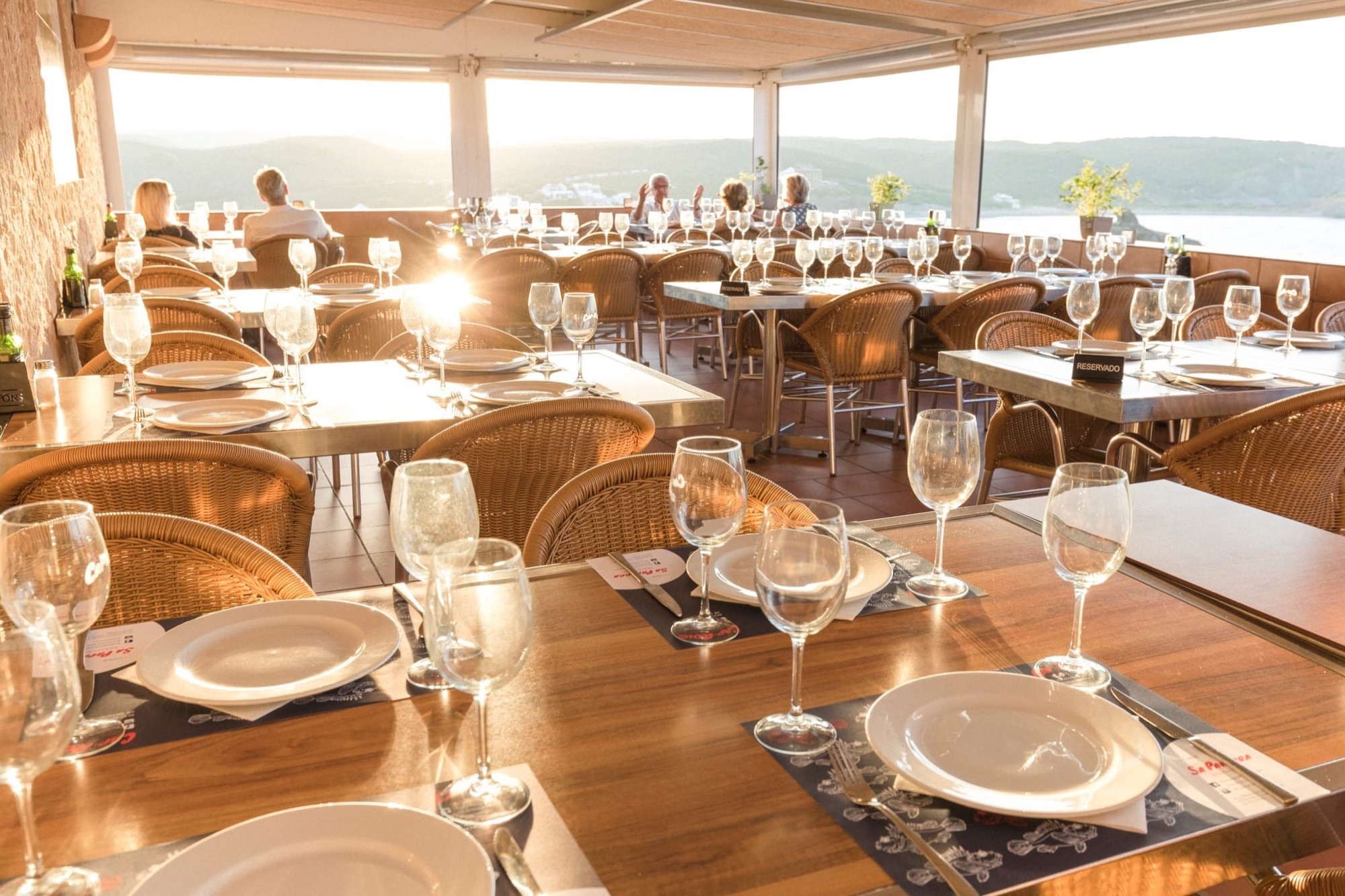 Une table dressée pour le dîner près d'une fenêtre donnant sur la mer