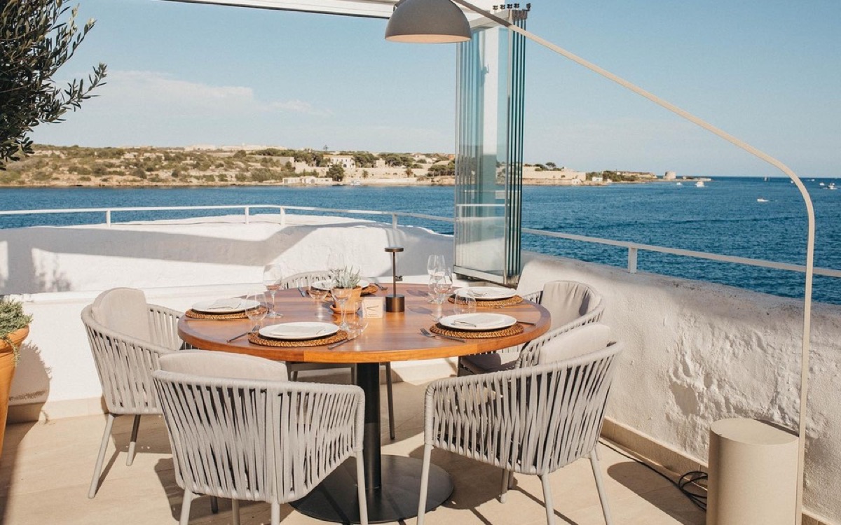 Une table dressée pour le déjeuner au-dessus de l'eau, sur la côte de Minorque