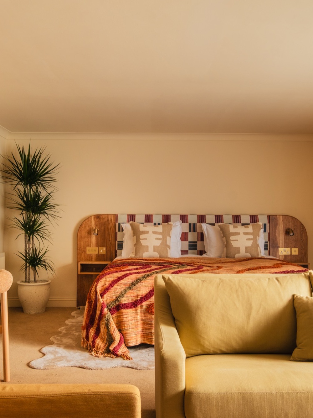A guest suite with handcrafted headboard and warm textiles – Guest suite