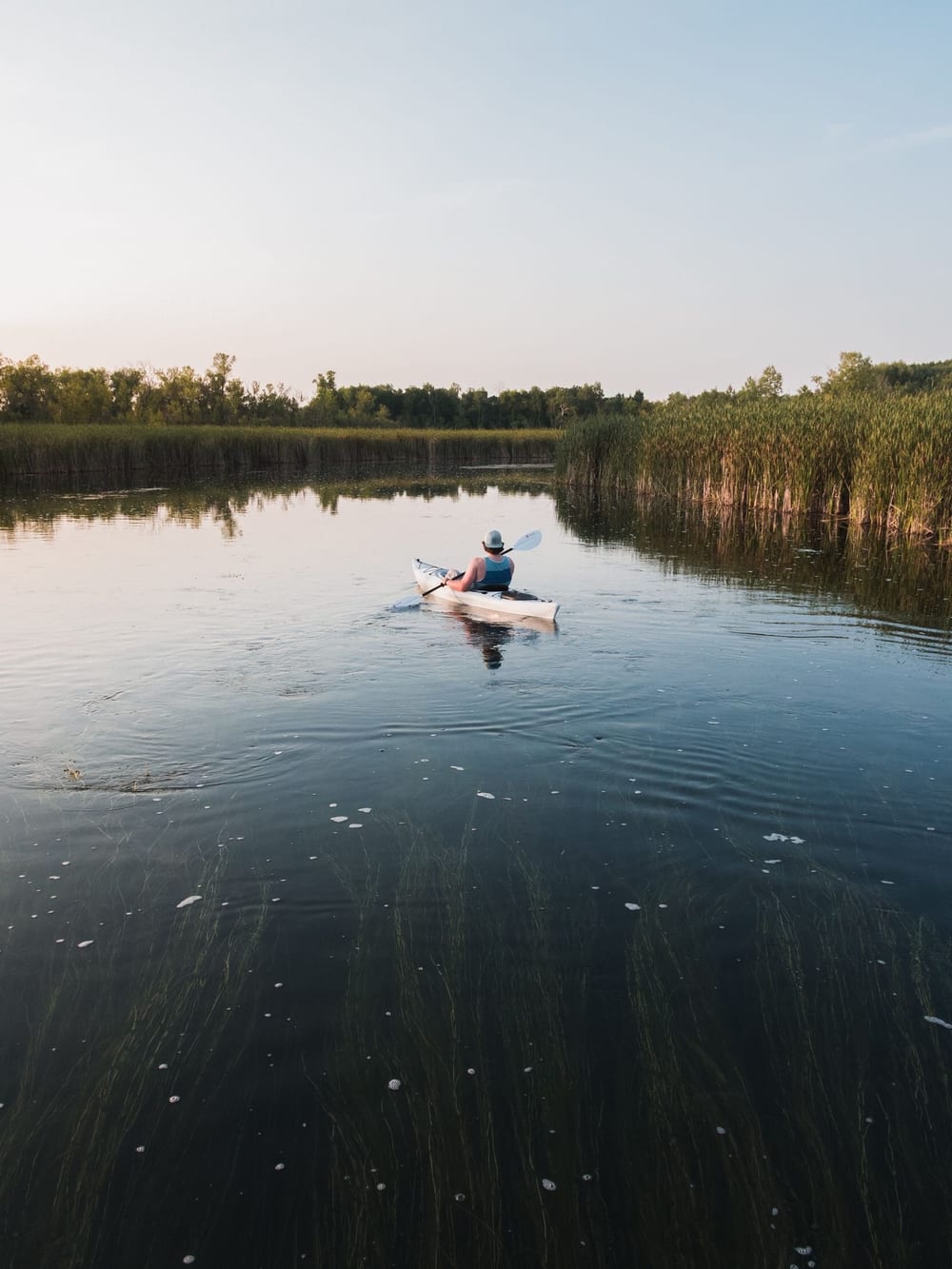 A kayaker crossing calm open water – Lakeside