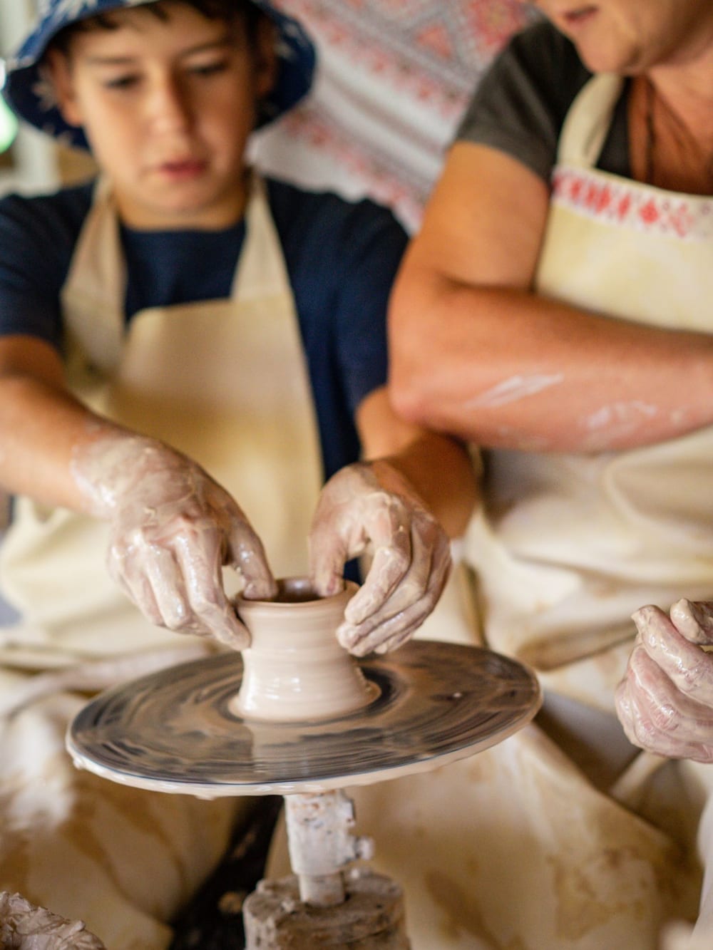 Hands shaping clay on a potter’s wheel – Craft workshop
