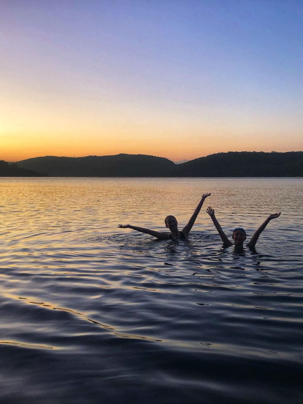 Swimmers in open water at sunset – Wild swimming