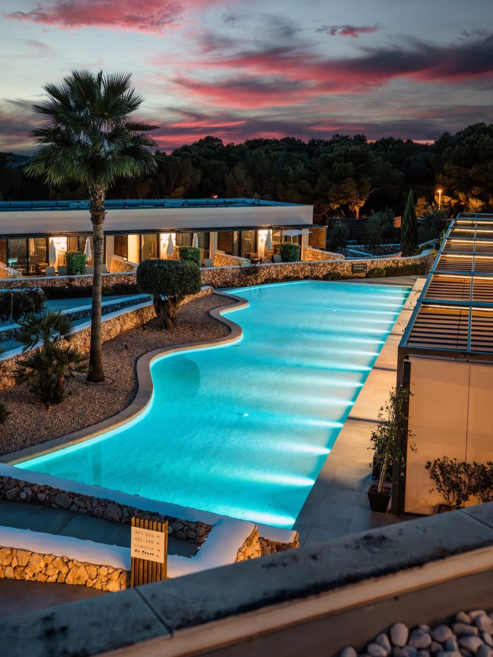 A hotel pool glowing beneath a pink dusk sky – Hotel pool