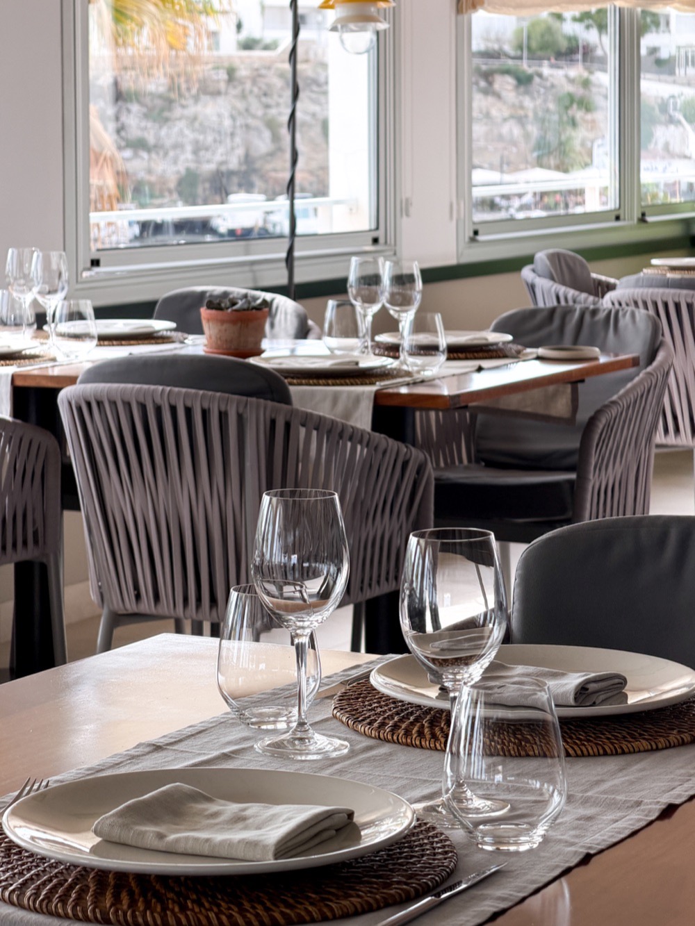 A dining table set beside tall windows – Island dining