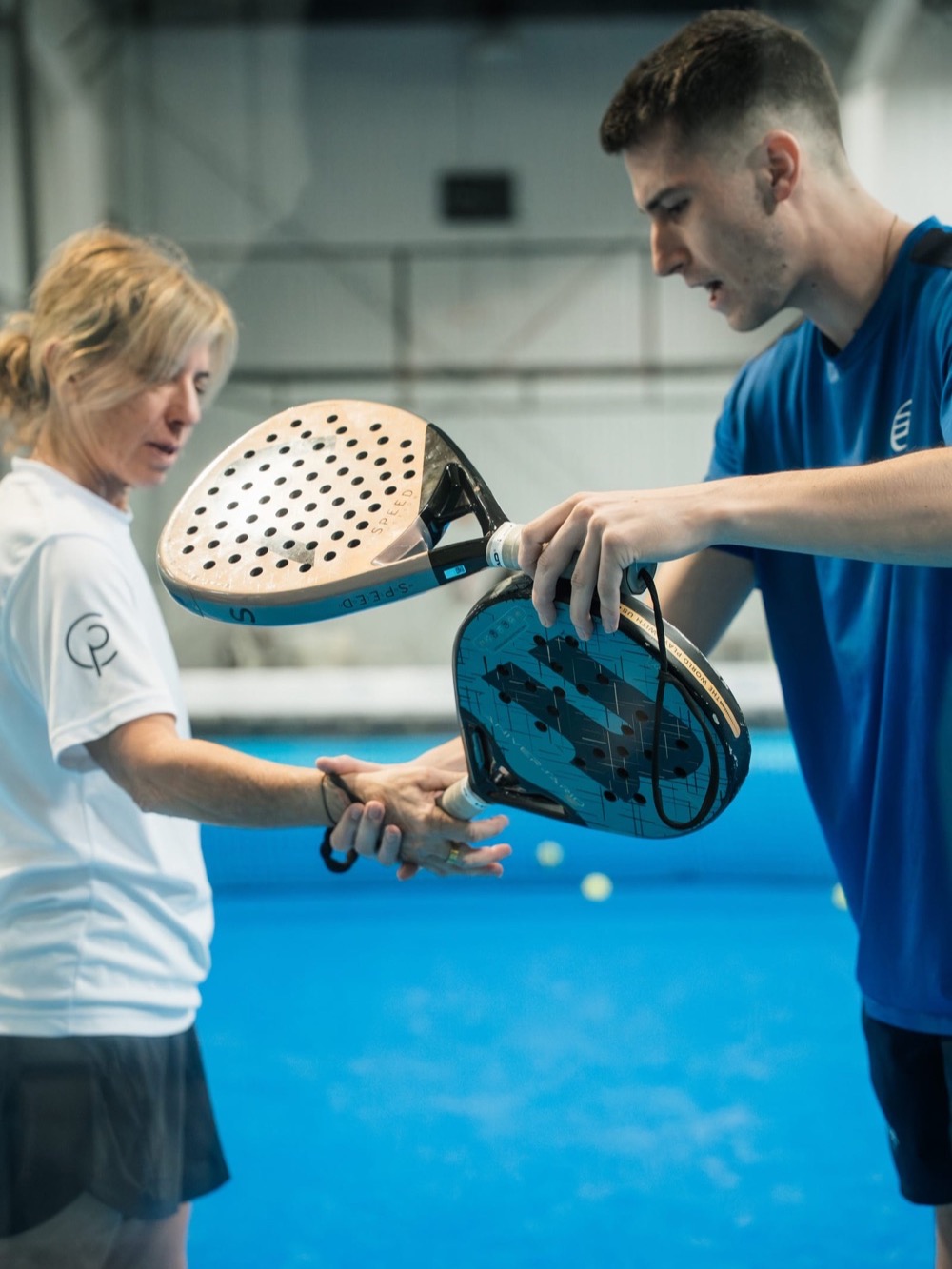 A coach adjusting a player’s grip on court – Padel