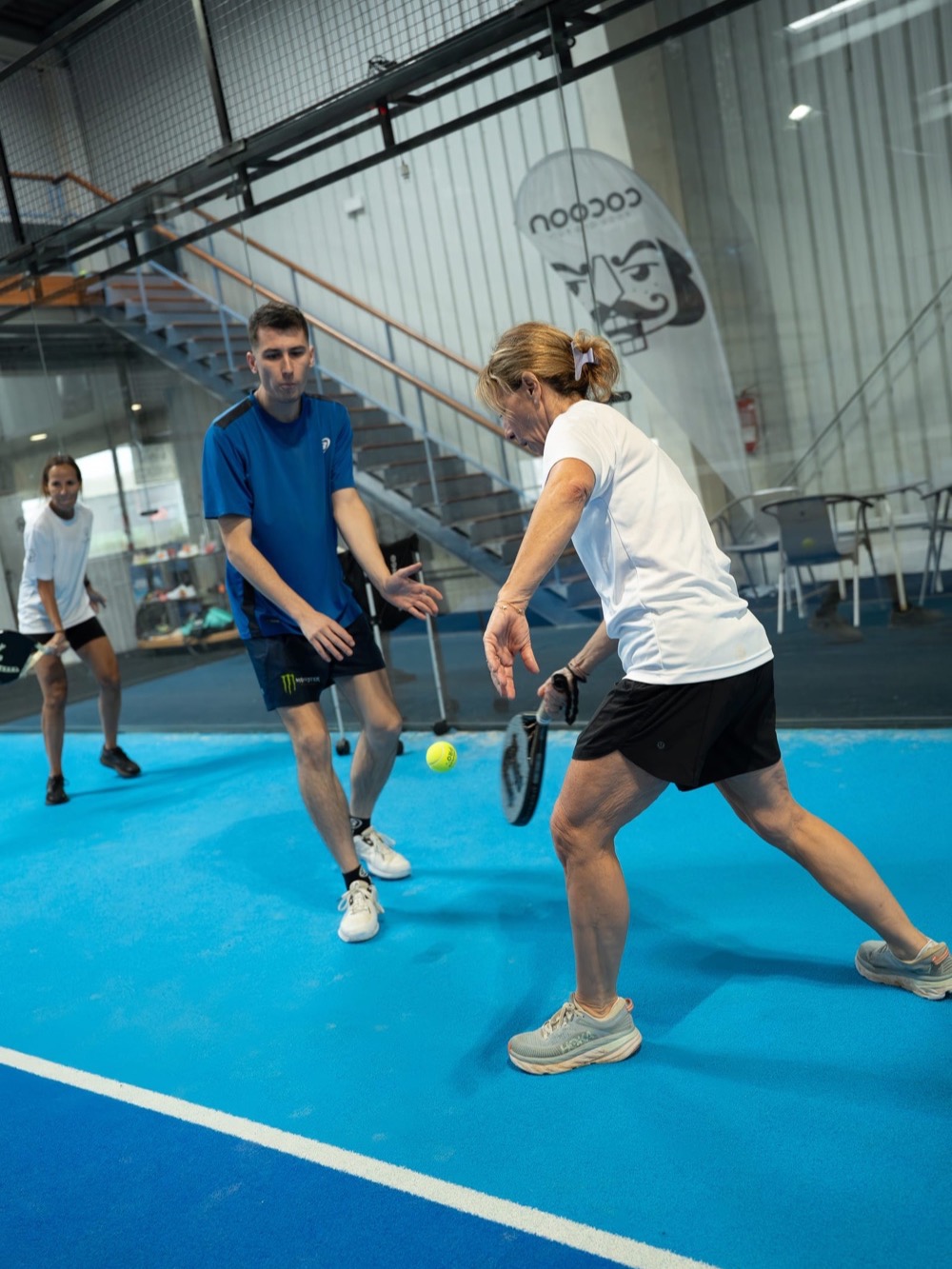 A coach and player in the middle of a rally – Padel